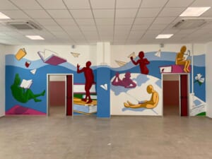 Veduta d'insieme del murale sulla lettura in un atrio