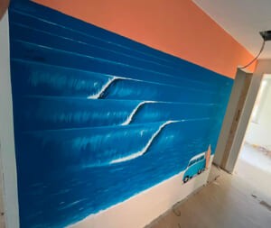 Parete dipinta con mare blu e onde bianche