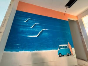 Murale d'interni con onde stilizzate e un furgoncino azzurro