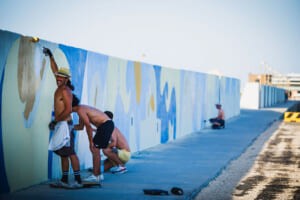 Gli artisti dipingono il muro del molo