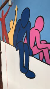 Murale con sagome colorate di persone che leggono