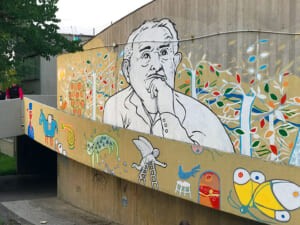 Dettaglio del murale con il ritratto di Tonino Guerra e uccelli colorati