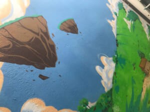 Dettaglio di un murale con rocce fluttuanti nel cielo