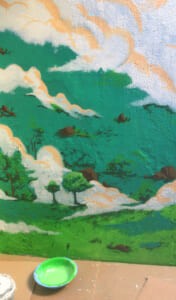 Dettaglio di un murale con colline verdi e nuvole