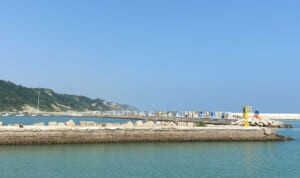 Il molo del porto con il faro e il muro dipinto