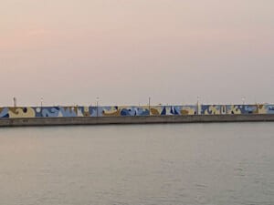 Il muro del molo dipinto visto da lontano