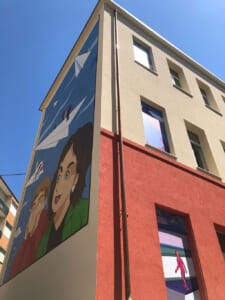 Facciata di un edificio con murale vista dal basso