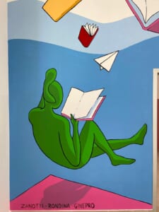Dettaglio di una figura verde che legge circondata da libri volanti