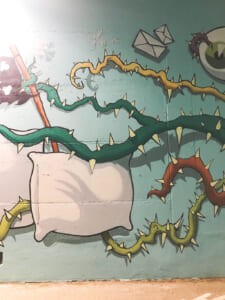 Dettaglio del murale con un cuscino e rami
