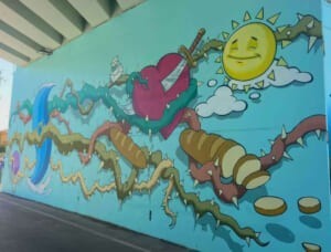 Murale "The World of Camillas" con rami, cuore e sole sorridente